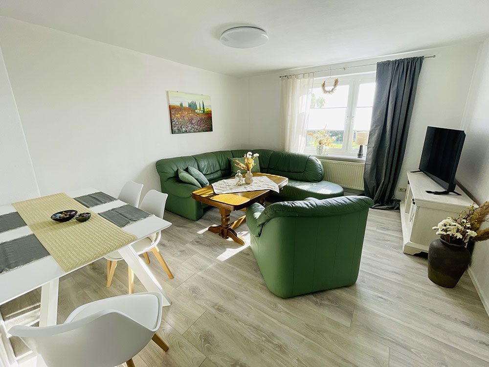 Wohnbereich des Monteurzimmer in Ballin Wohnung Nr. 7 bei Neubrandenburg mit Ledersofa, Esstisch, TV