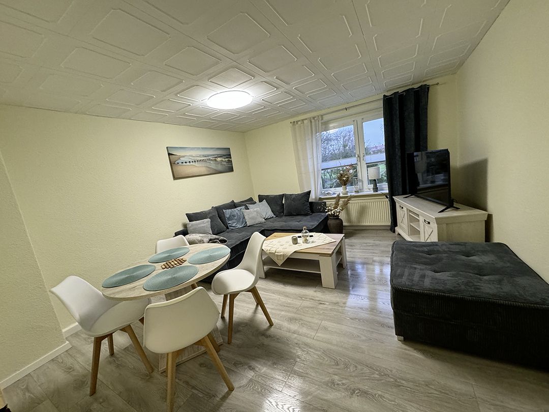 Wohnbereich des Monteurzimmer in Ballin Wohnung Nr. 7 bei Neubrandenburg mit Ledersofa, Esstisch, TV